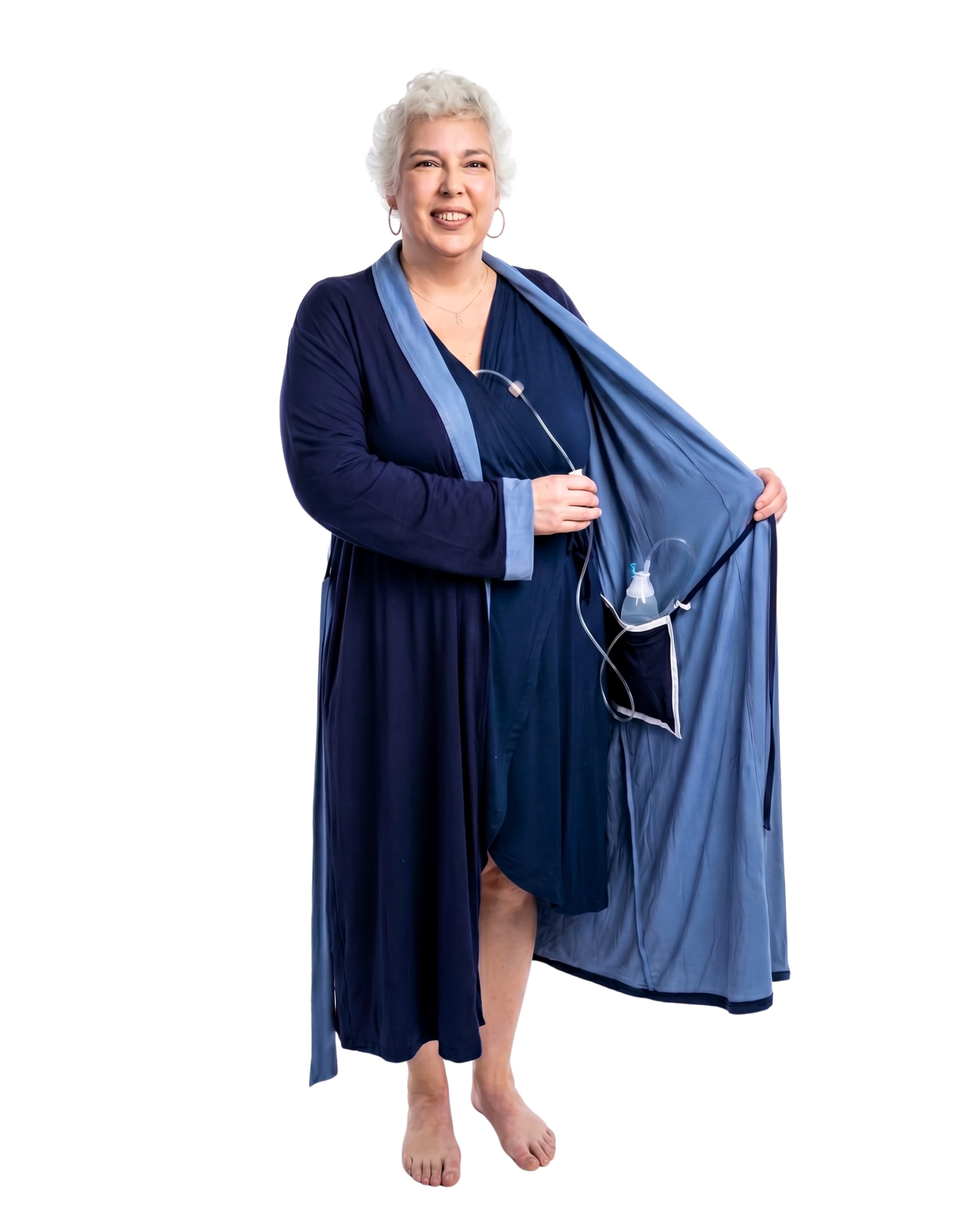 Woman wearing a navy two-toned recovery robe with an surgical bag going into the internal pocket on a white background