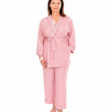 A woman wearing pink striped recovery  pajamas set against a white background