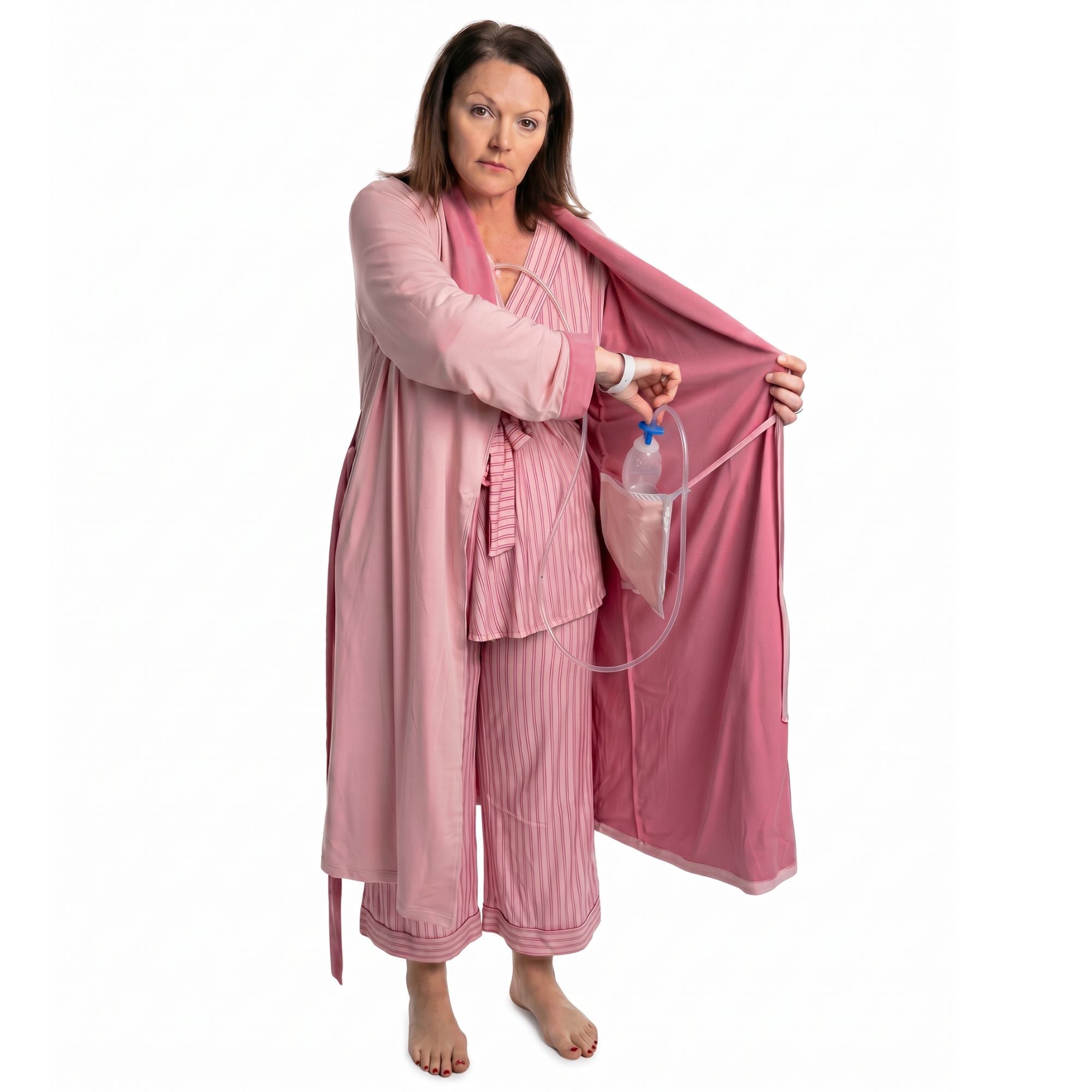 Woman wearing a pink recovery robe with an surgical bag going into the internal pocket on a white background