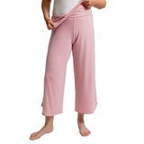 Person wearing pink fold down pants on a white background