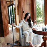 Woman sitting in a chair with an IV stand next to her, holding a phone.