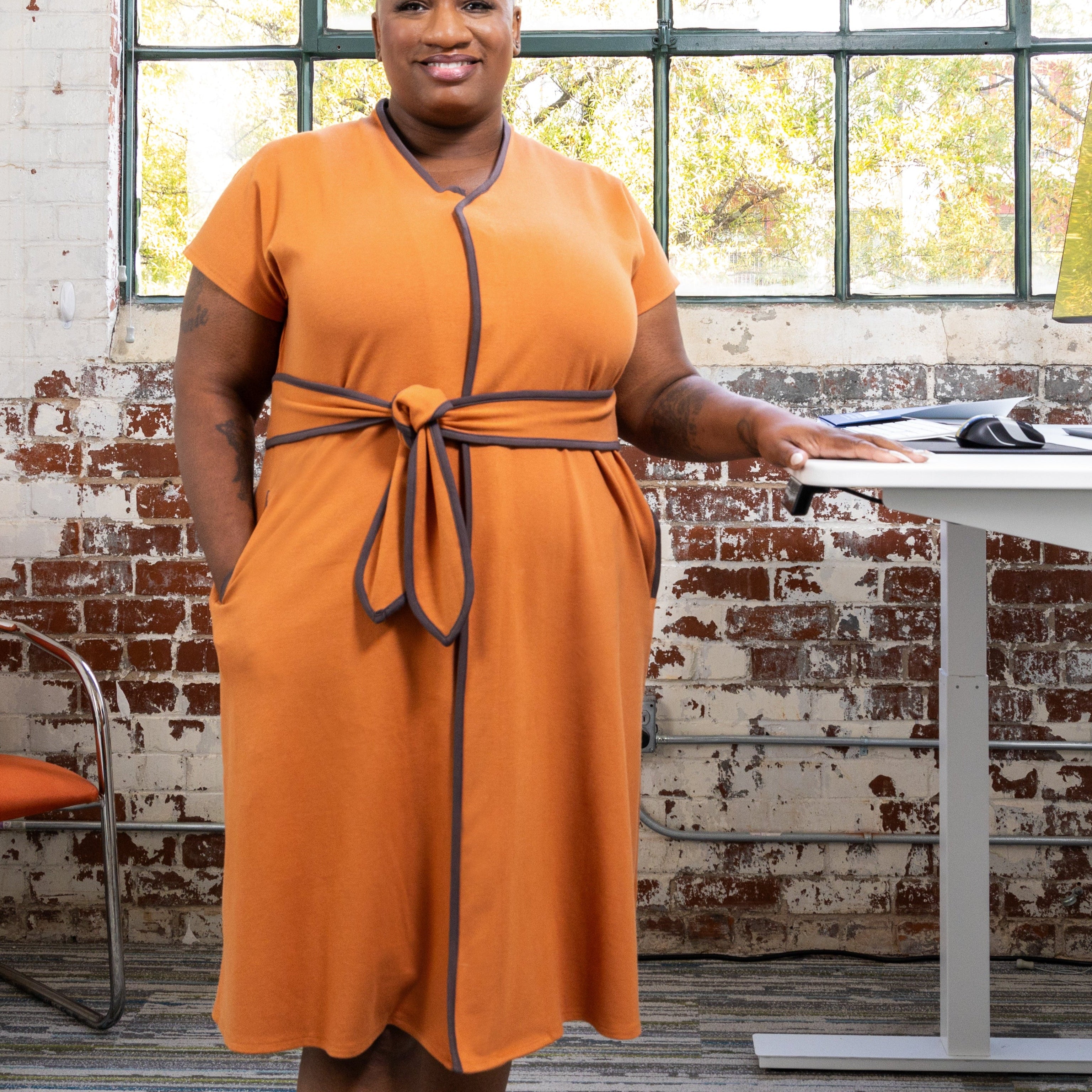 Full shot of the cinnamon dress in a lifestyle work environment