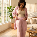 woman recovering from surgery in a pink post surgery pajamas set showing the adaptive pants that have a fold-over waistband