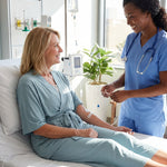 woman wearing sage green recovery pajamas with short sleeves in a clinical room with an IV