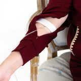 Close-up of a person wearing a mulberry long-sleeve top with cut-out arm zipper access for medical devices