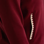 Close-up of a mulberry recovery set with a decorative scalloped cream detail on the pocket