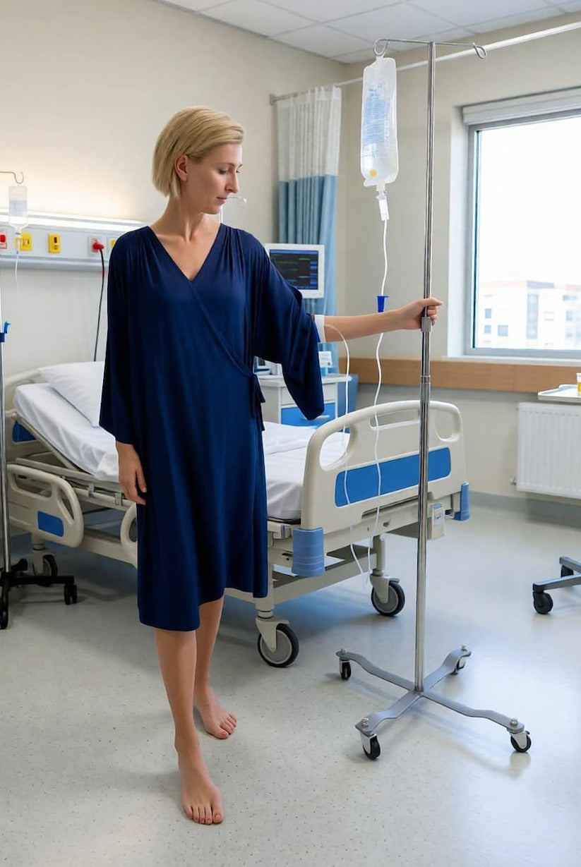 Woman in a hospital room with an IV stand and medical equipment.