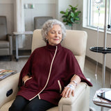 Woman wearing a maroon infusion jacket while attached to an IV pole in a treatment room