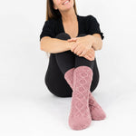 Woman wearing pink cable knit socks  against a white background