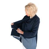 Woman wearing a navy blue wrap shirt worn open to show the interior pocket for surgical drains on a white background