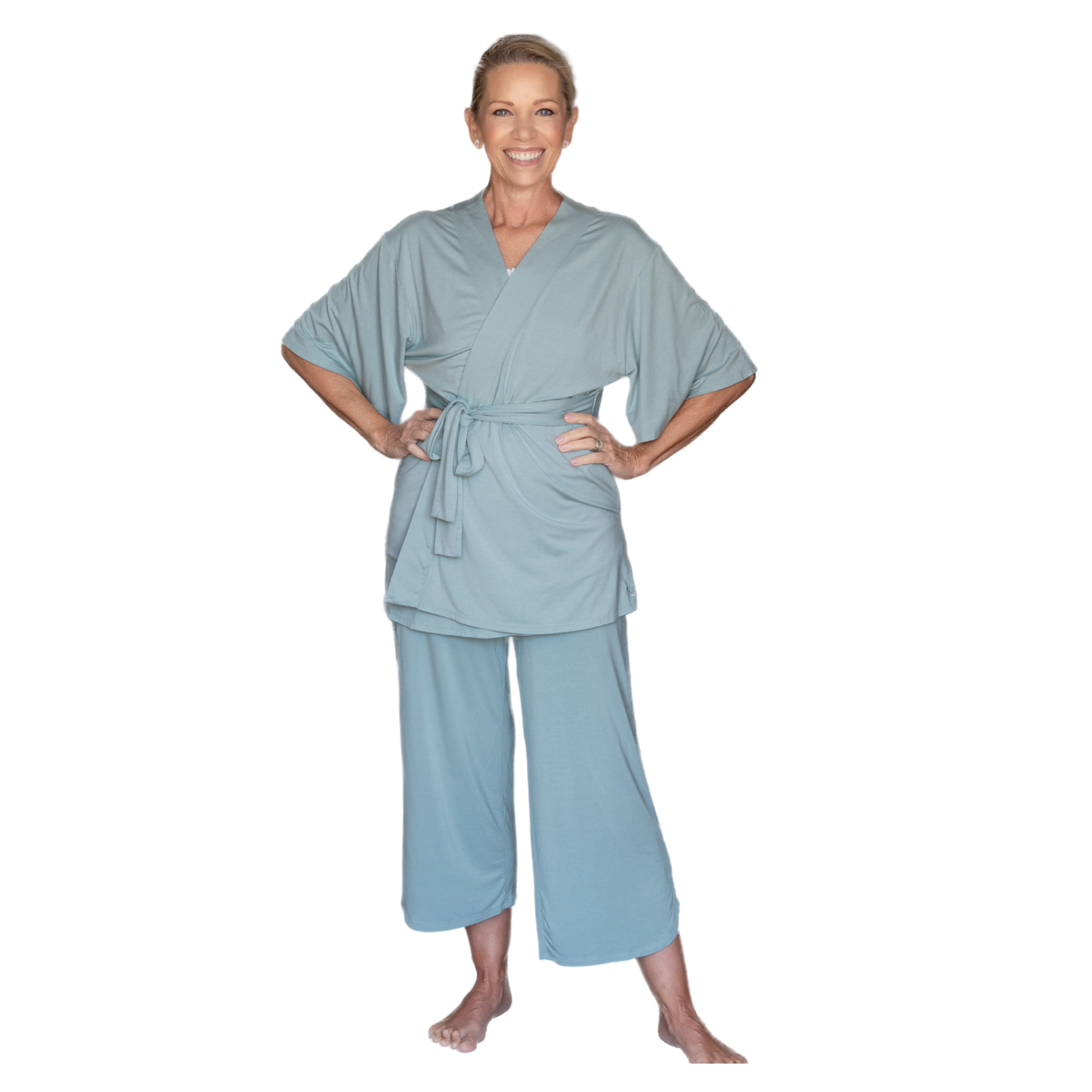Woman wearing a short sleeve sage robe and pants set on a white background