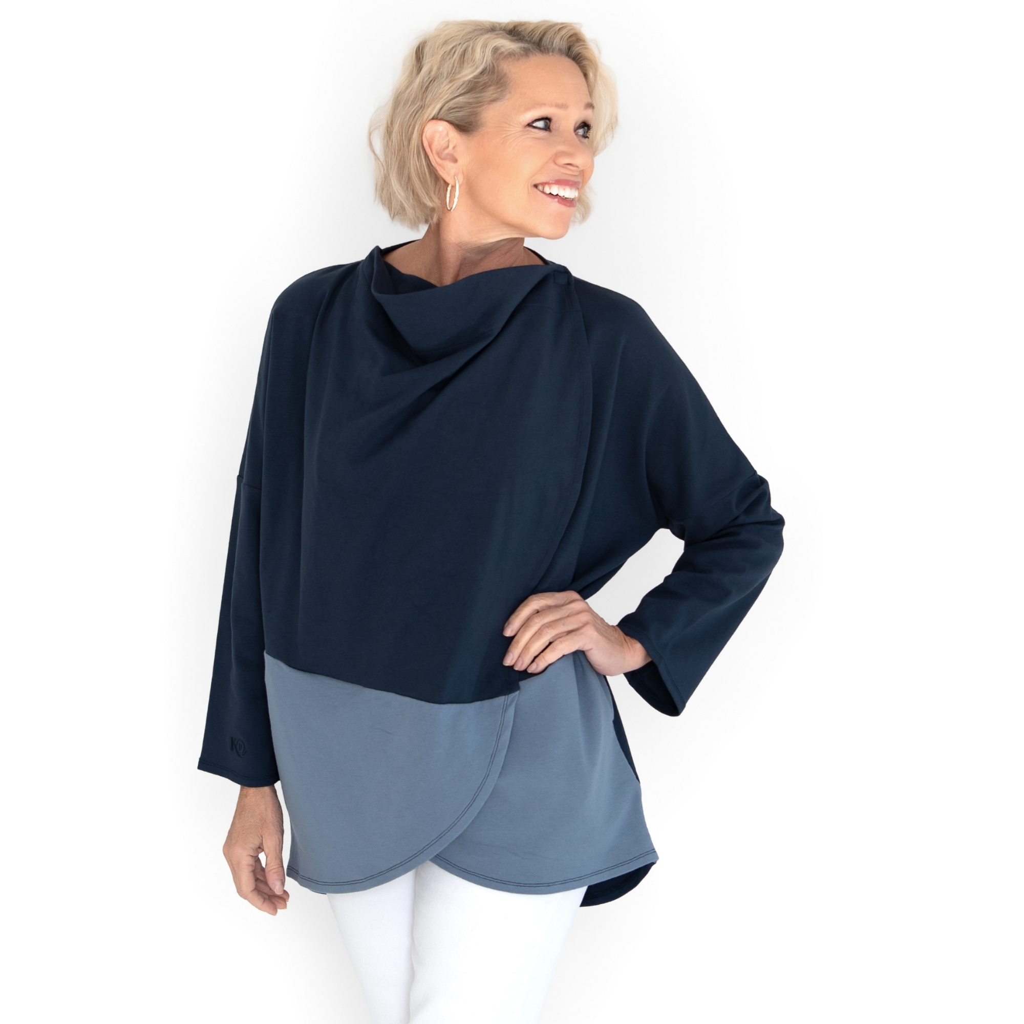 Woman wearing a two-tone navy and gray top with snap neck on a white background
