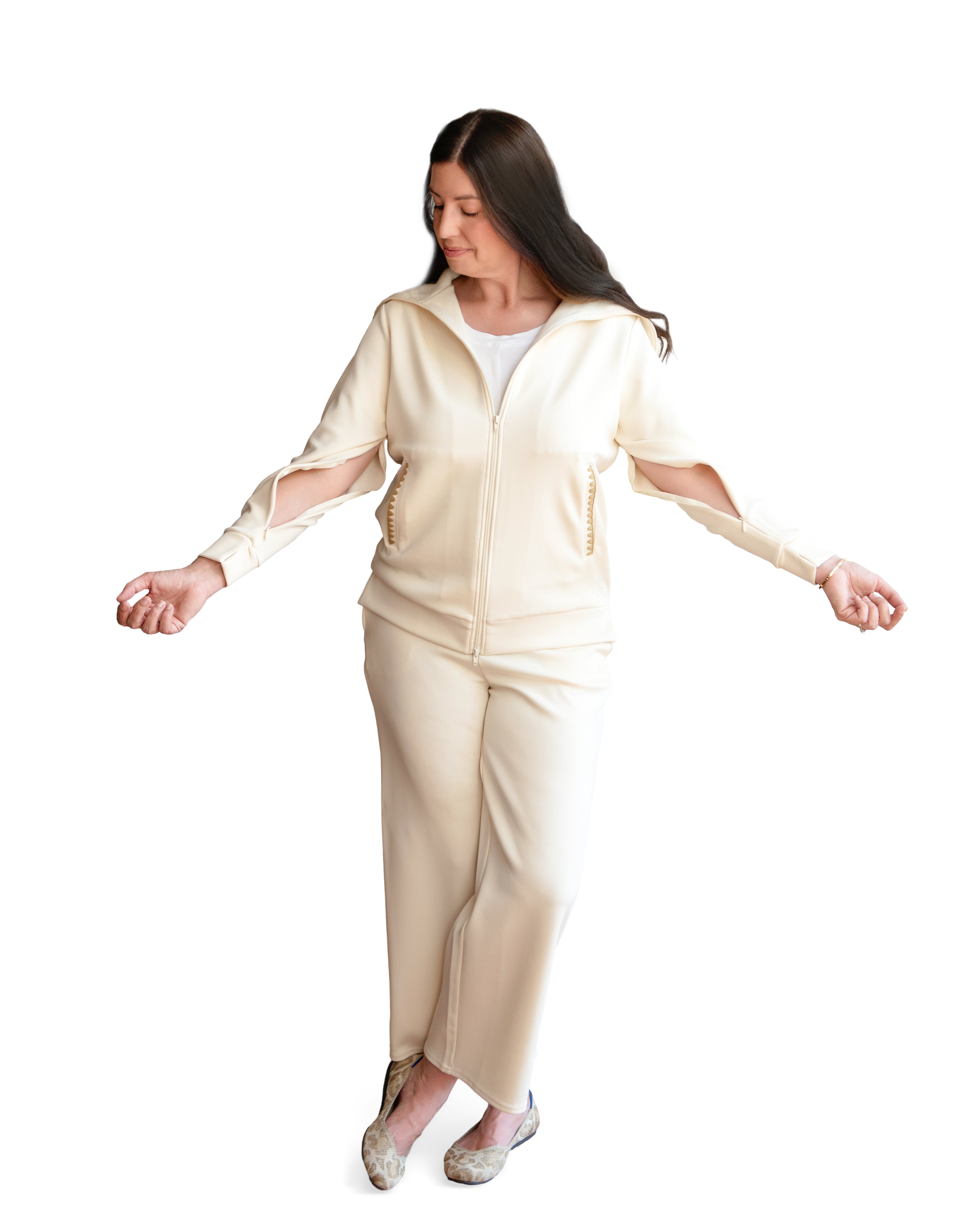 Woman wearing a cream-colored adaptive loungewear outfit with arm zippers for easy medical access on a white background