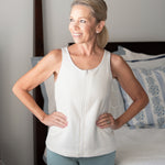 Woman wearing a white sleeveless top with zipper front for easy on and off during limited mobility after surgery