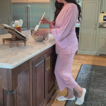 Woman in her kitchen wearing the KickIt Home Recovery Pajamas