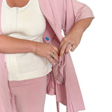 Person wearing a pink recovery pajamas over a white top highlighting the interior drain pocket